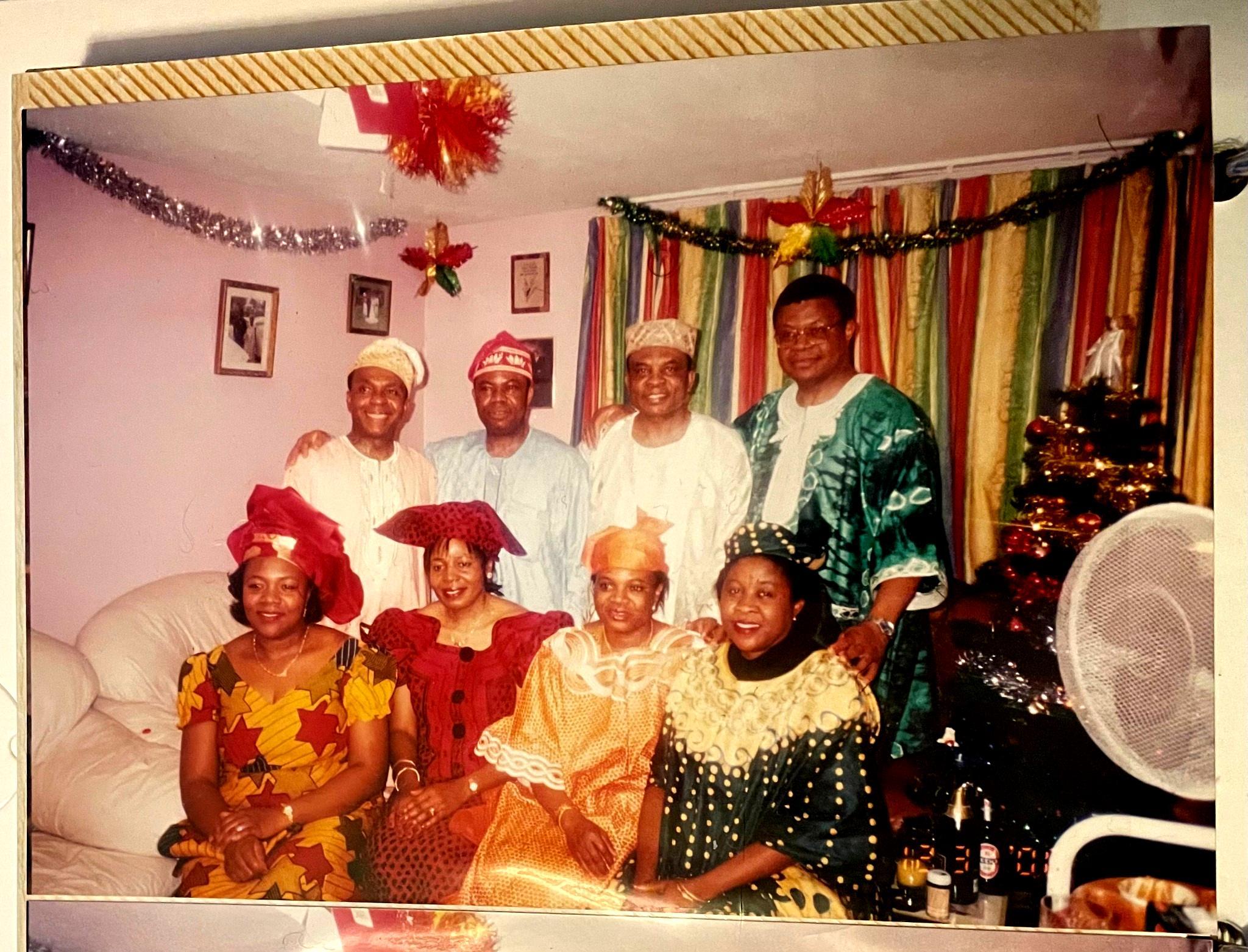Uncles and aunties gathered at a New Year’s Eve party in London, smiling and dressed in colourful Nigerian clothing.